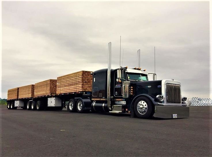 Peterbilt sleeper truck hauling a flatbed load of lumber